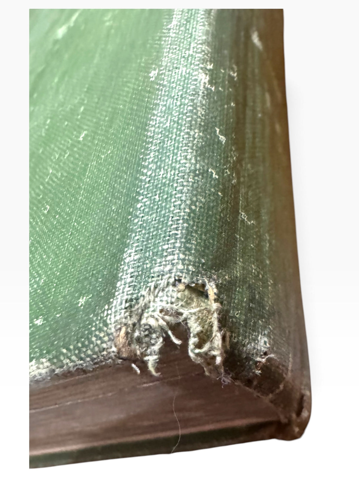 Close-up of the worn green cloth corner on a 1920 Zane Grey vintage book showing fraying and board exposure.